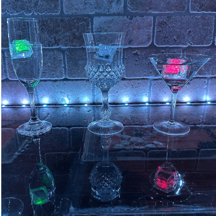 Three empty glasses with a single ice insideit