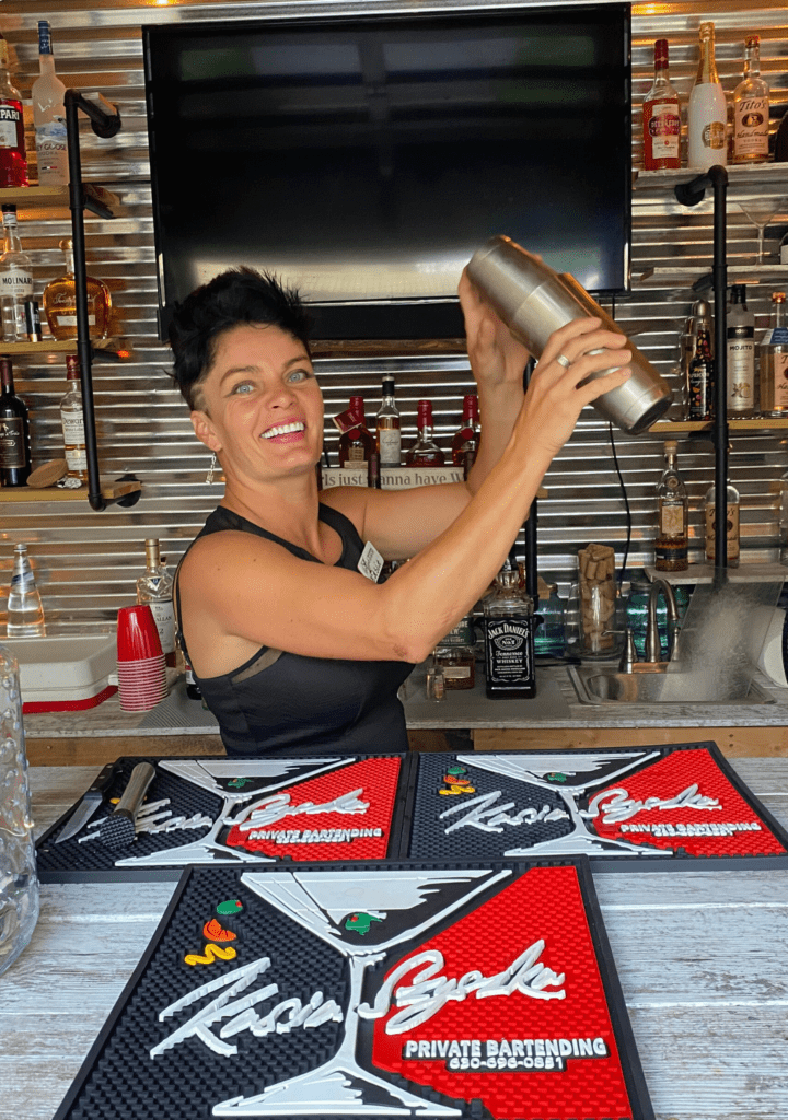 A lady making a cocktail with a shaker