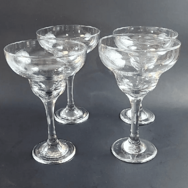 A closeup look at four glasses kept together with gray background