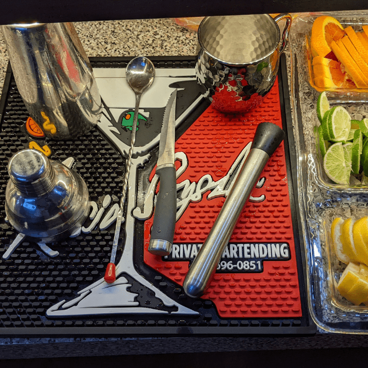 A tray of a bartender filled with different tools and lemons